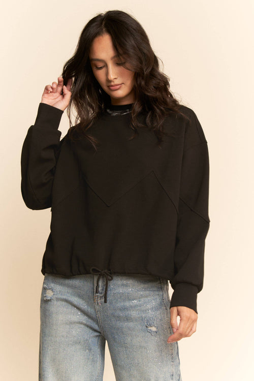 Woman wearing Davi & Dani black zigzag seam sweatshirt with drawstring hem and relaxed fit.