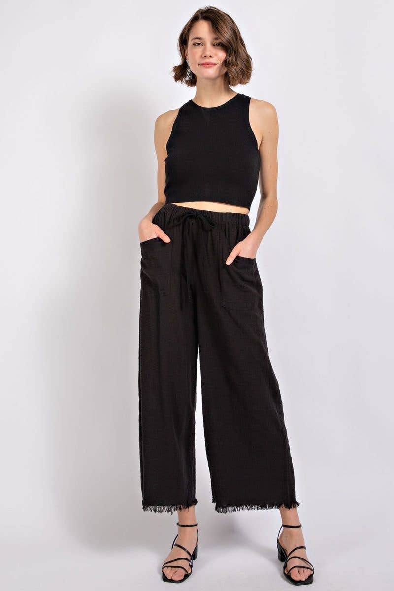 Gigio black 100% cotton wide-leg pants with drawstring waist, oversized front pockets, and frayed cropped hems.
