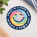 Life is Good Tie Dye Smile Good Day round sticker on a bright neutral lifestyle background.