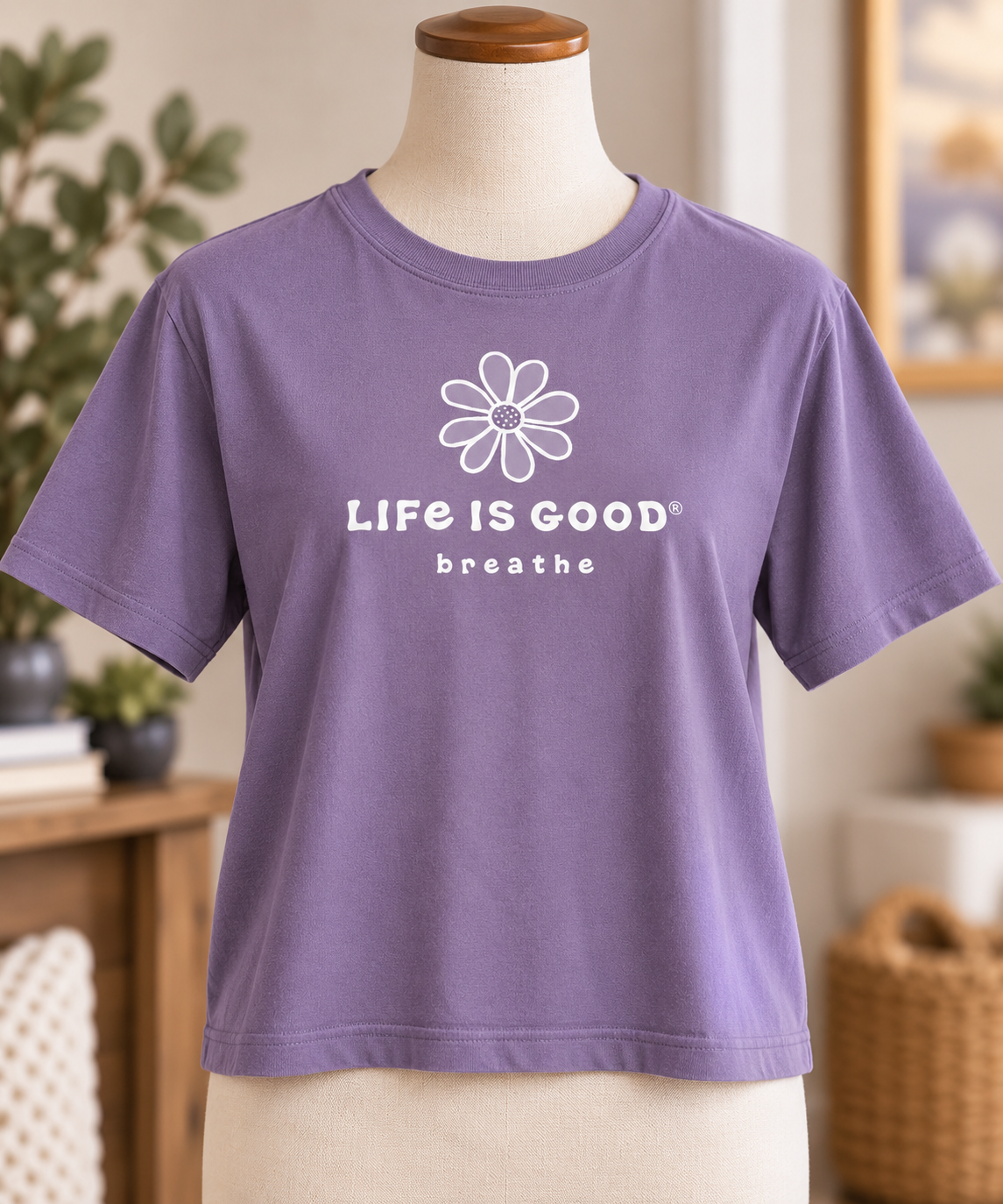 Life is Good women’s dusk purple boxy-fit T-shirt featuring a white daisy and “Life is Good Breathe” graphic, displayed on a torso mannequin.