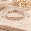 Lotus and Luna Winter Blush bracelet with pink and white beads and silver accents displayed on a neutral stone surface.
