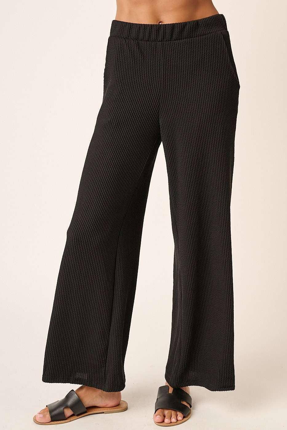 Black rib knit wide leg pants with elastic waistband and side pockets.